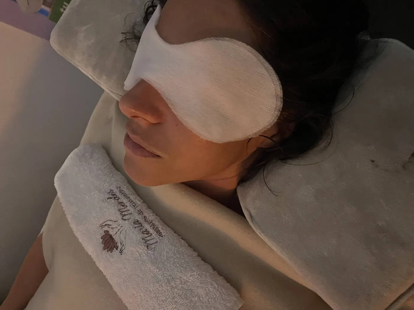 Cliente reclinada com máscara de olhos numa sessão de relaxamento